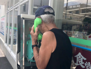 Masafumi Nagasaki making a call in a phone booth